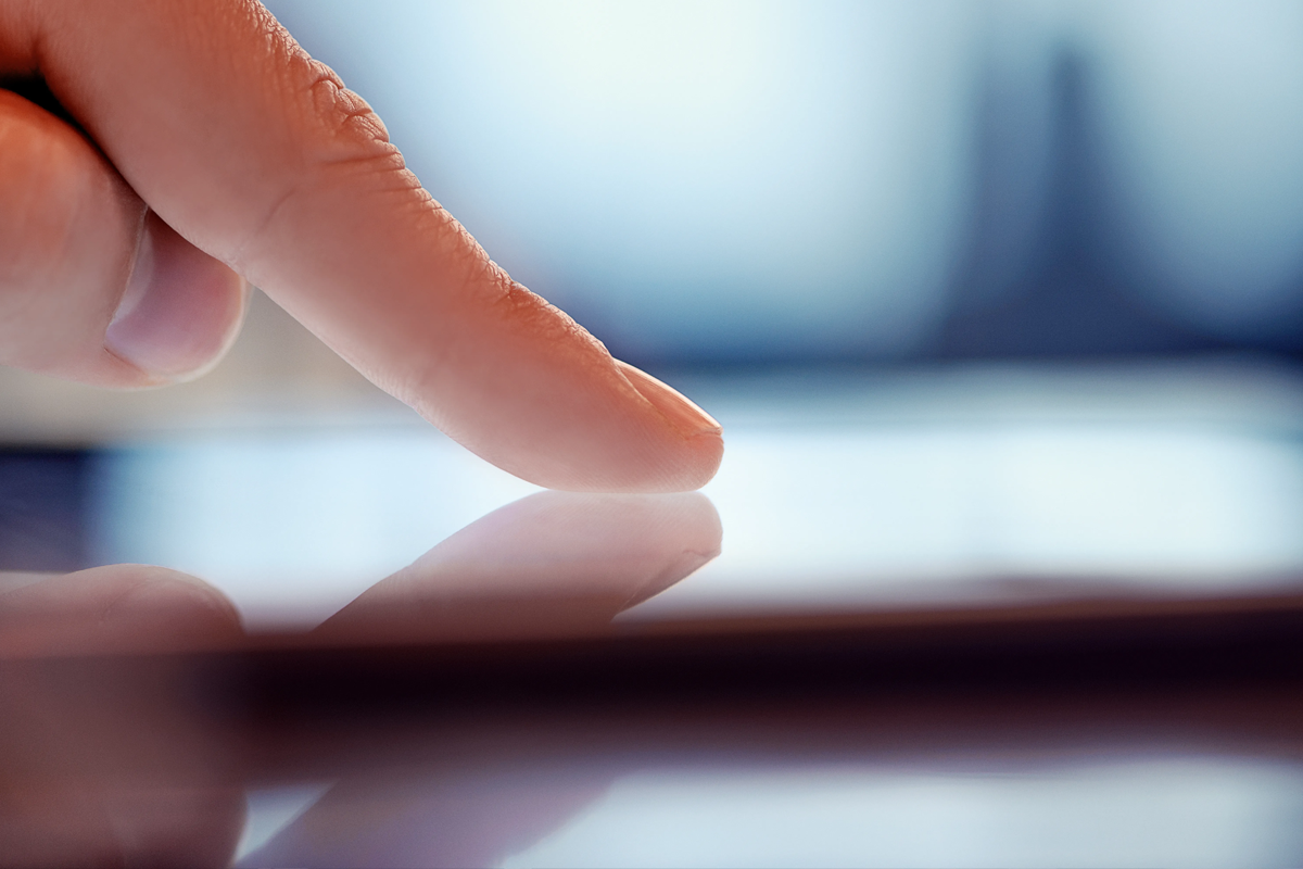 Närbild av ett finger som vidrör en digital skärm
