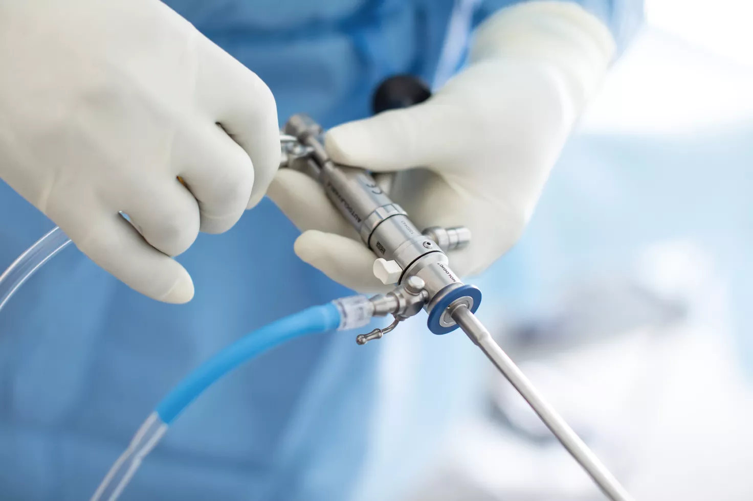 Handskbeklädda händer som håller ett medicinskt instrument