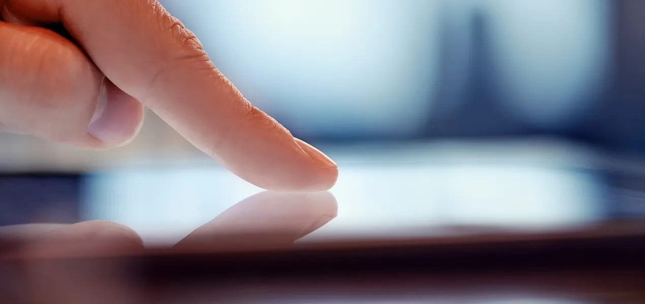 Närbild av ett finger som vidrör en digital skärm