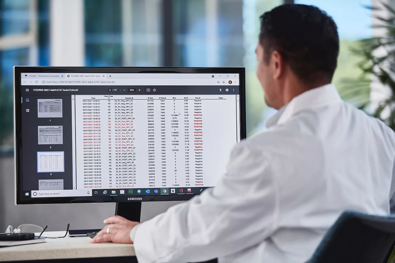 Laboratorietekniker som tittar på data på en bildskärm i laboratoriemiljö