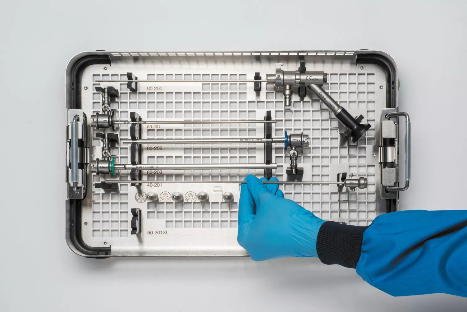 Handskbeklädd hand arbetar med en medicinsk bricka på ett bord.