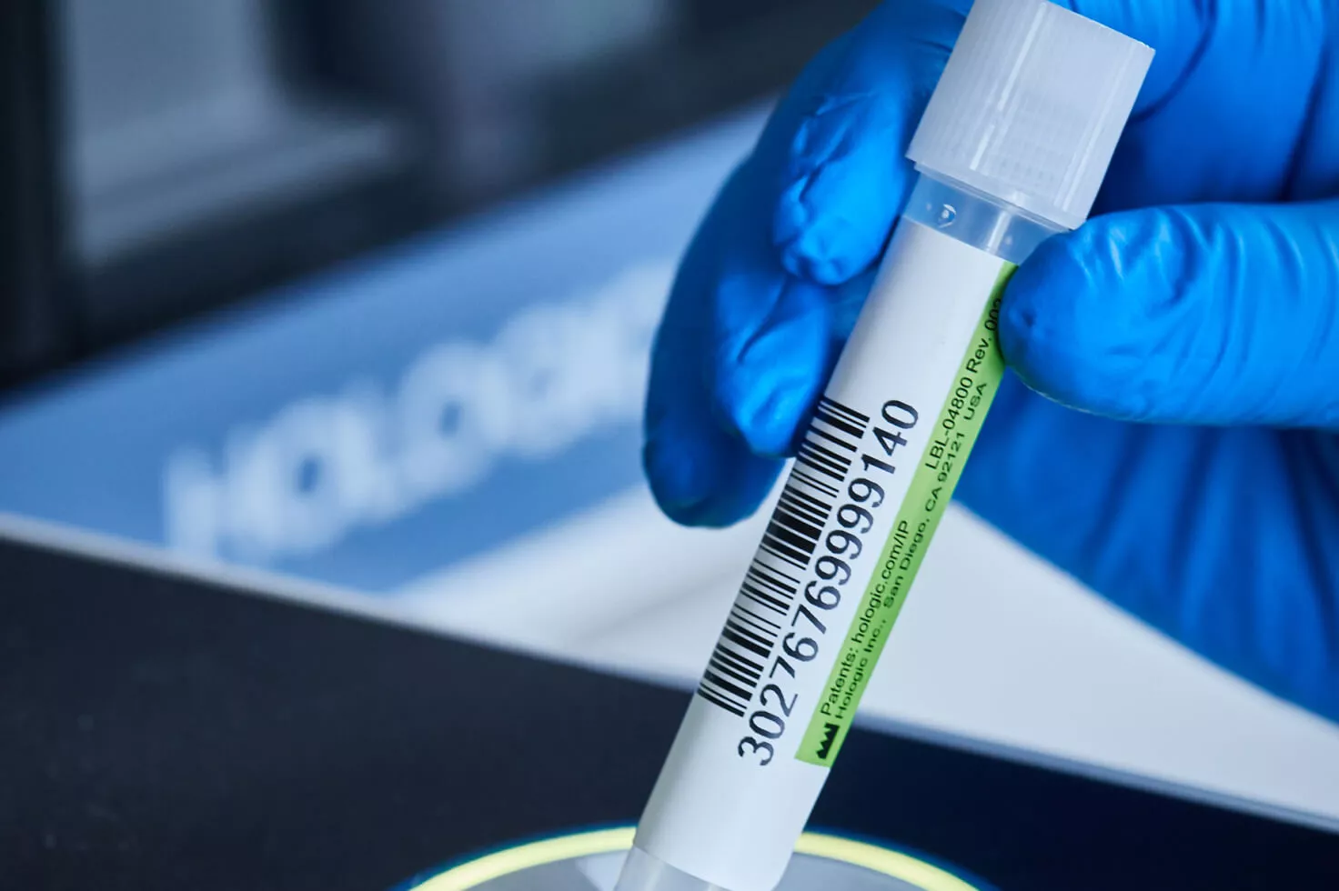 Närbild av handskbeklädd hand som håller en provburk